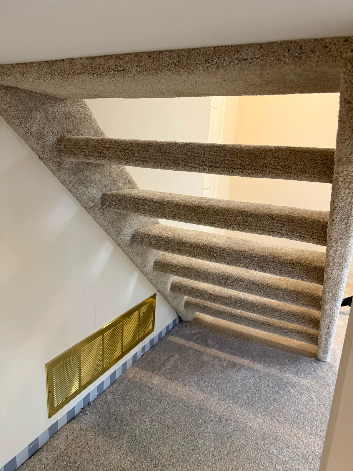 The same open riser stairs finished, with carpet wrapped around the front and underside of every tread