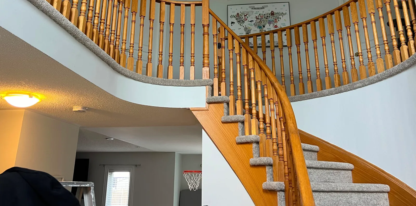 A sweeping oak staircase with carpet fitted to each tread, the oak risers and the curved skirt left bare the whole way up