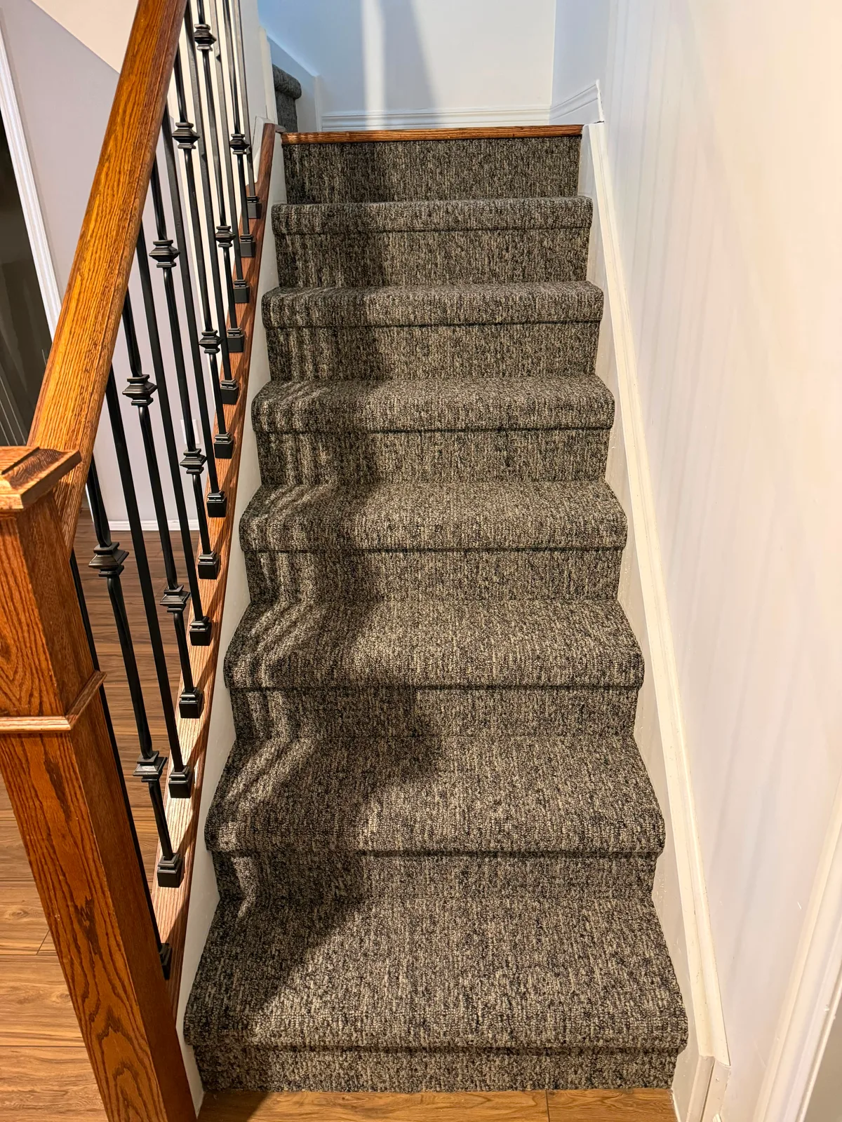 The same staircase from the landing above, the tweed running true down the middle of every tread